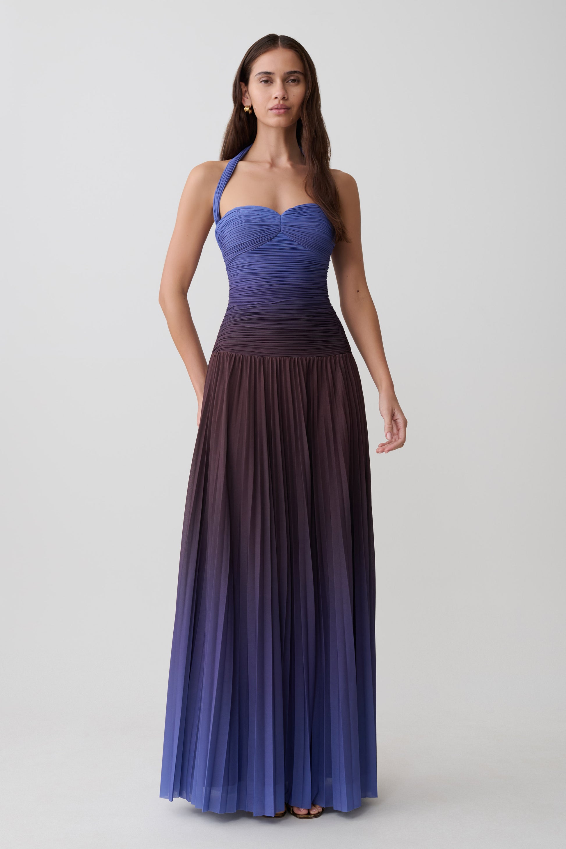 Woman wearing a chocolate and blue ombre pleated halter midi dress.