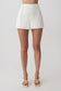 Woman wearing white shorts with lace trim.