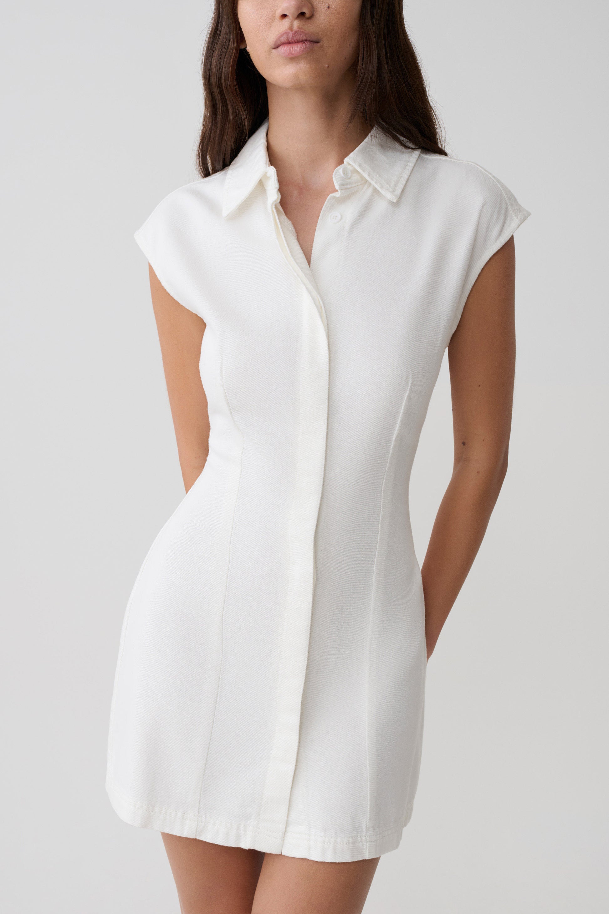 Woman wearing a white collared mini denim dress.