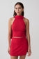 Woman wearing a red halter backless knit top with matching skirt.