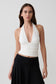 Woman wearing a white modal gathered halter top. 