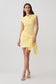 Woman wearing a yellow knit mini dress with sash.