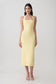 Woman wearing a yellow suiting halter midi dress.