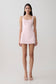 Woman wearing a pink satin mini dress.