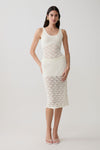 Woman wearing a sleeveless knit crochet top with matching skirt.