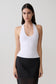 Woman wearing a white ribbed tank.