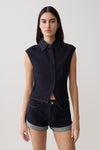 Woman wearing dark blue collared denim longline top with matching denim shorts.