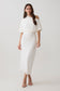 Woman wearing a white off-shoulder midi dress.