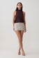 Woman wearing brown sleeveless modal draped bodysuit with a mini skirt.