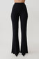 Woman wearing black flared pants.