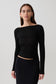 Woman wearing a black long-sleeve sheer top.