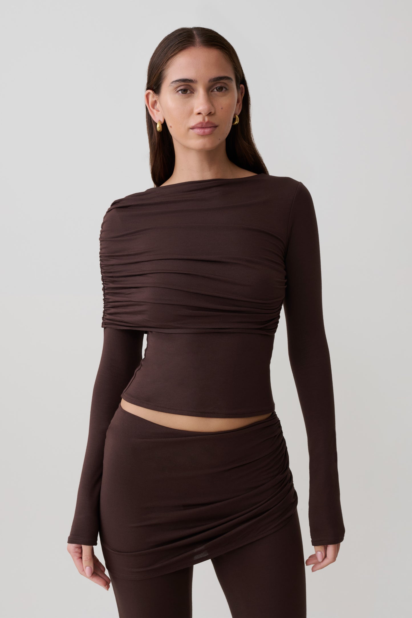 Woman wearing a brown long-sleeve overlay top.