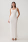 Woman wearing a white scoop neck jersey maxi dress.