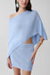 Woman wearing a light blue one shoulder knit cape top with matching skirt