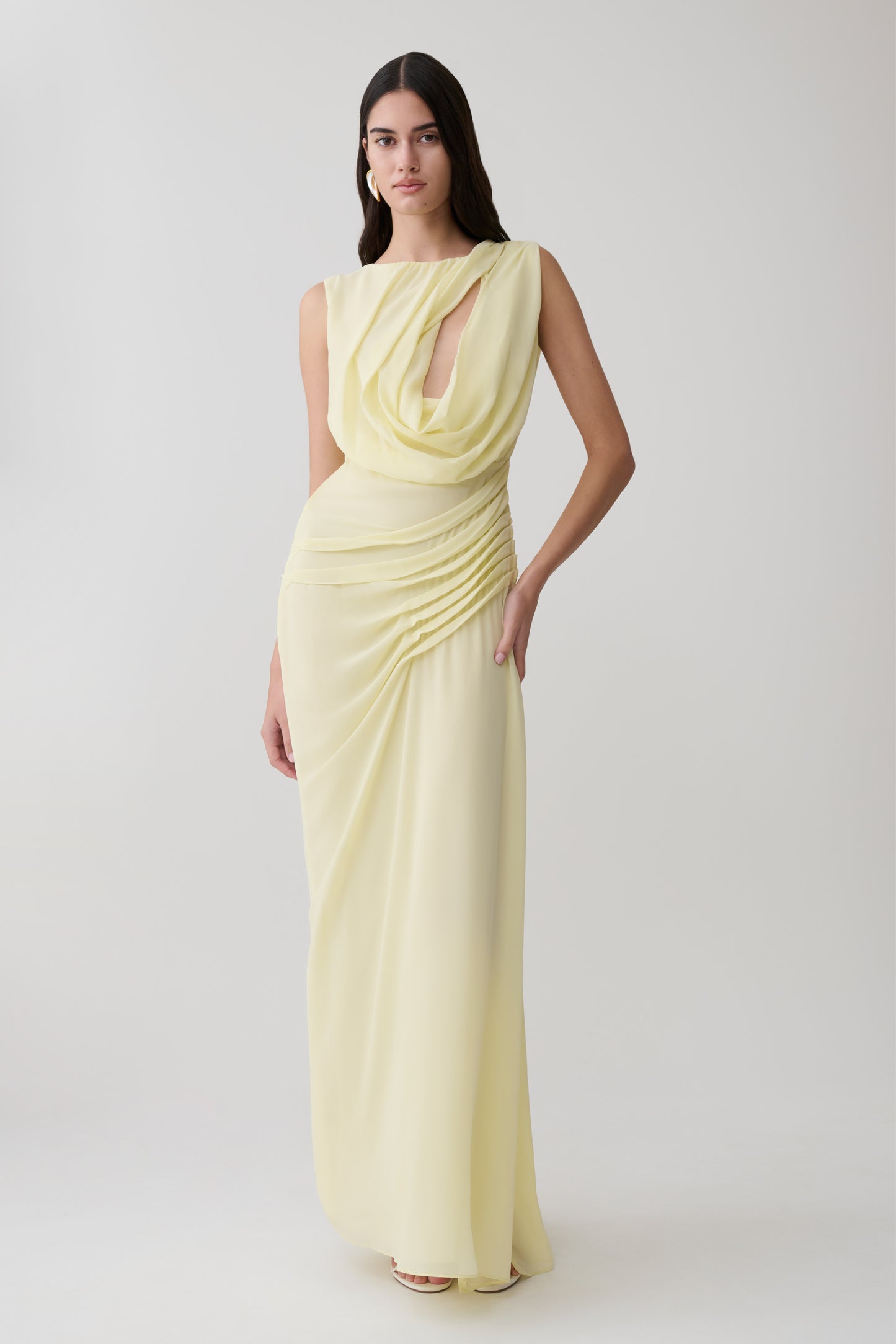 Woman wearing a light yellow chiffon maxi dress.
