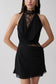 Woman wearing a black chiffon And lace halter mini dress.