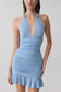 Woman wearing a blue halter mini dress.