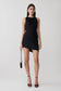 Woman wearing a black cowl back asymmetric mini dress.