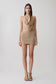 Woman wearing a gold lurex cowl neck top with matching mini skirt.
