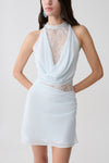 Woman wearing a light blue chiffon And lace halter mini dress.