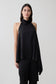 Woman wearing a black asymmetrical satin halter top.