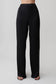 Woman wearing black straight leg satin pants.