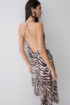 Woman wearing a zebra print low back chiffon top.