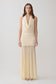 Woman wearing a white draped halter slinky maxi dress.