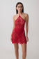 Woman wearing red crochet halter top with matching mini skirt.