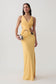 Woman wearing yellow draped jersey gown with hardware.