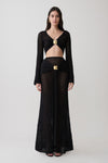 Woman wearing crochet long sleeve cropped top with matching maxi skirt.