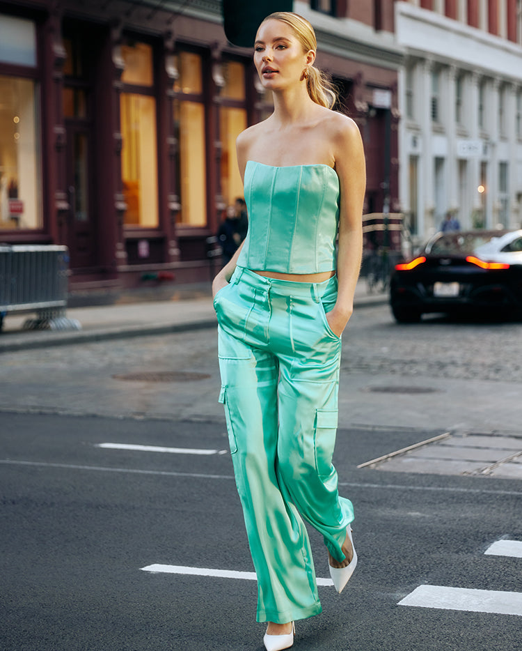 Image of woman wearing a turquoise satin corset and matching cargo pants