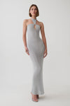 A woman modeling a light gray ribbed knit halter-neck maxi dress with a keyhole cutout at the chest, photographed against a seamless light gray studio background.