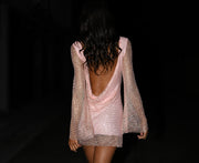 Image of woman in backless pink diamante dress.