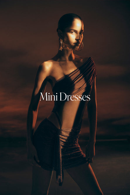 Model wearing a sheer mini dress with a dark, moody background and 'Mini Dresses' text.