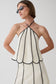 Woman wearing a black and white panelled halter sleeveless top.