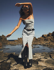 Image of woman wearing denim strapless top with matching front split midi denim skirt