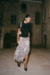 Woman in black top and zebra print chiffon midi skirt. 