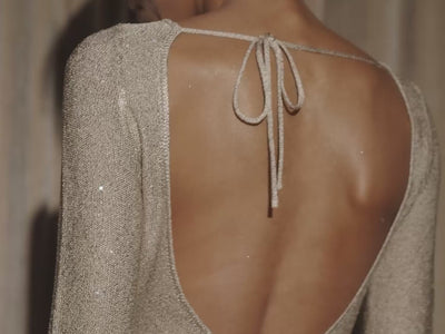 Video of woman in gold backless dress.