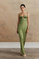 Woman wearing a green embellished satin maxi dress.